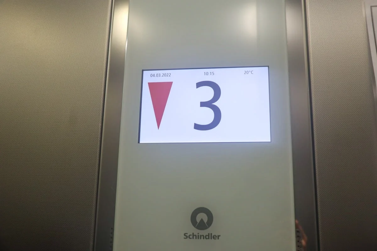 Écran d'ascenseur affichant le chiffre 3 et une flèche rouge