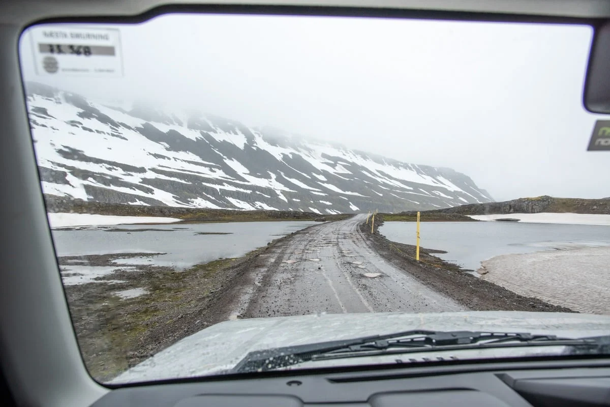 Piste de gravier enneigée vue depuis l'intérieur d'un véhicule