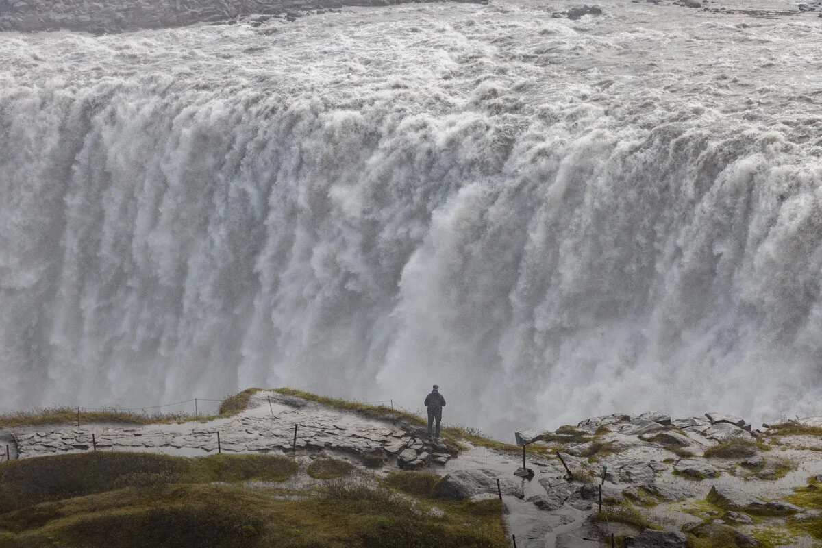 une personne face à une cascade d'eau puissante