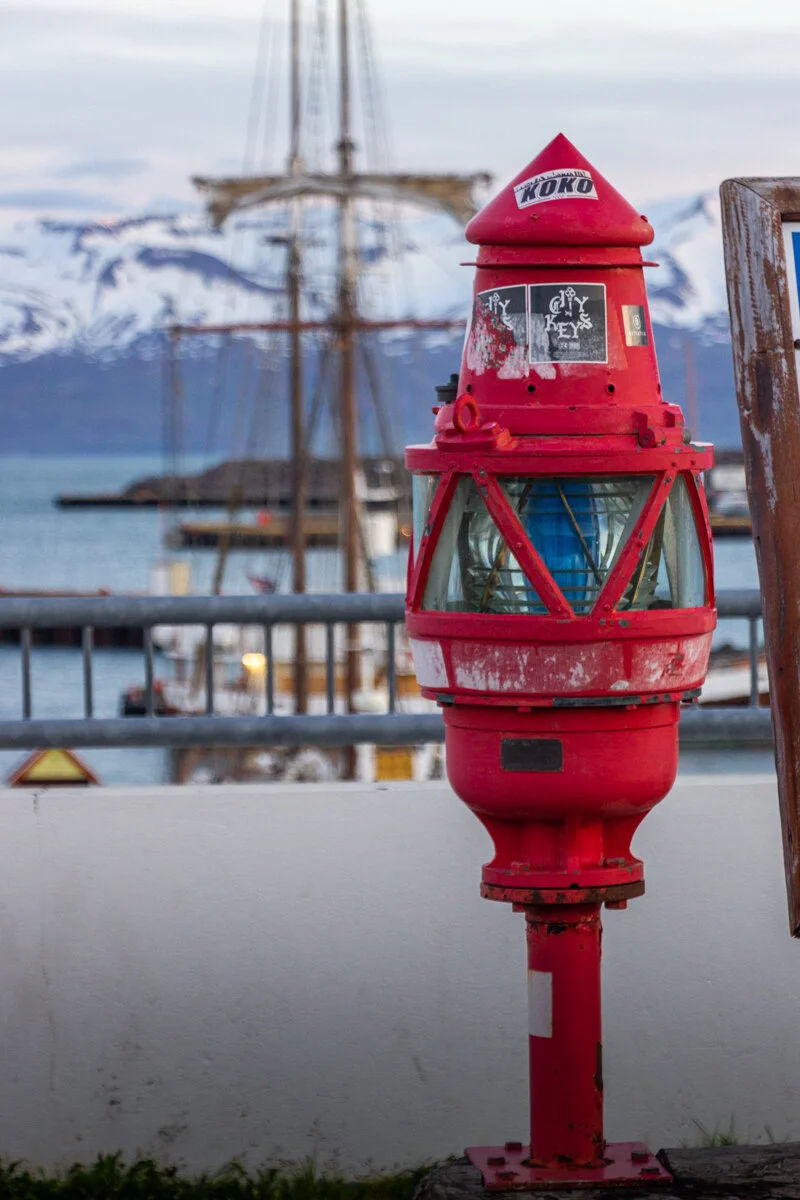 lanterne rouge de port avec voilier en arrière-plan
