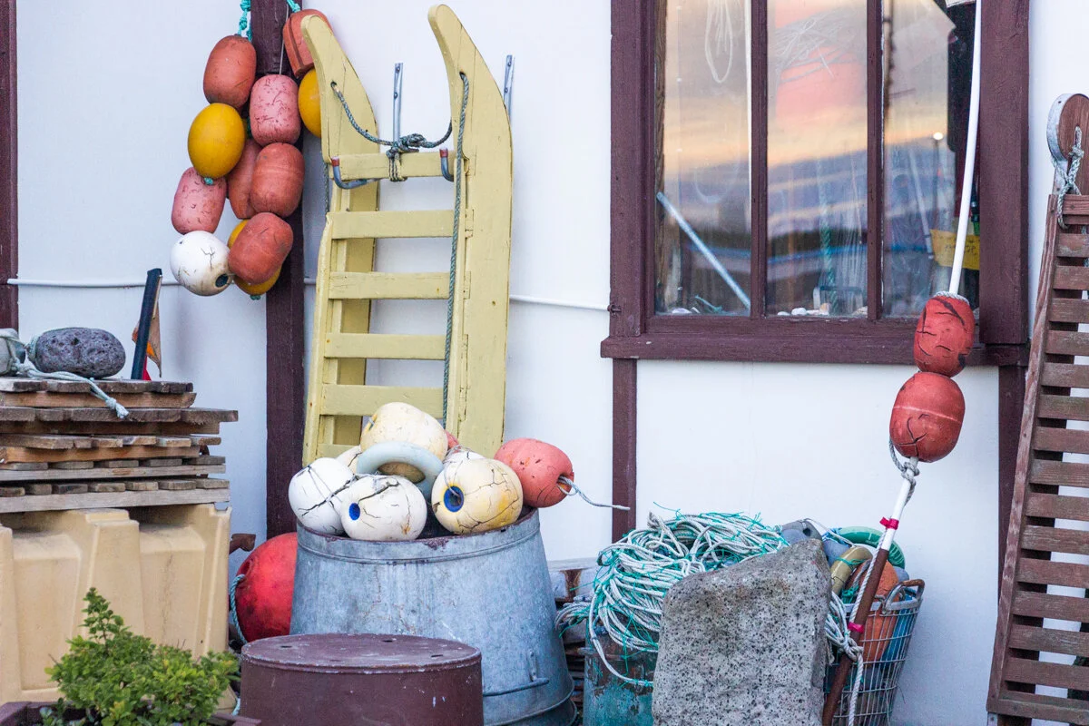 des filets de pêche et des bouées rouges et oranges accrochées à un mur
