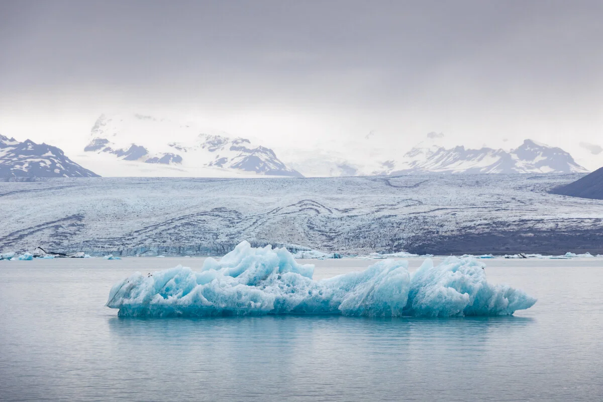 un iceberg bleu flotte dans une lagune glaciaire