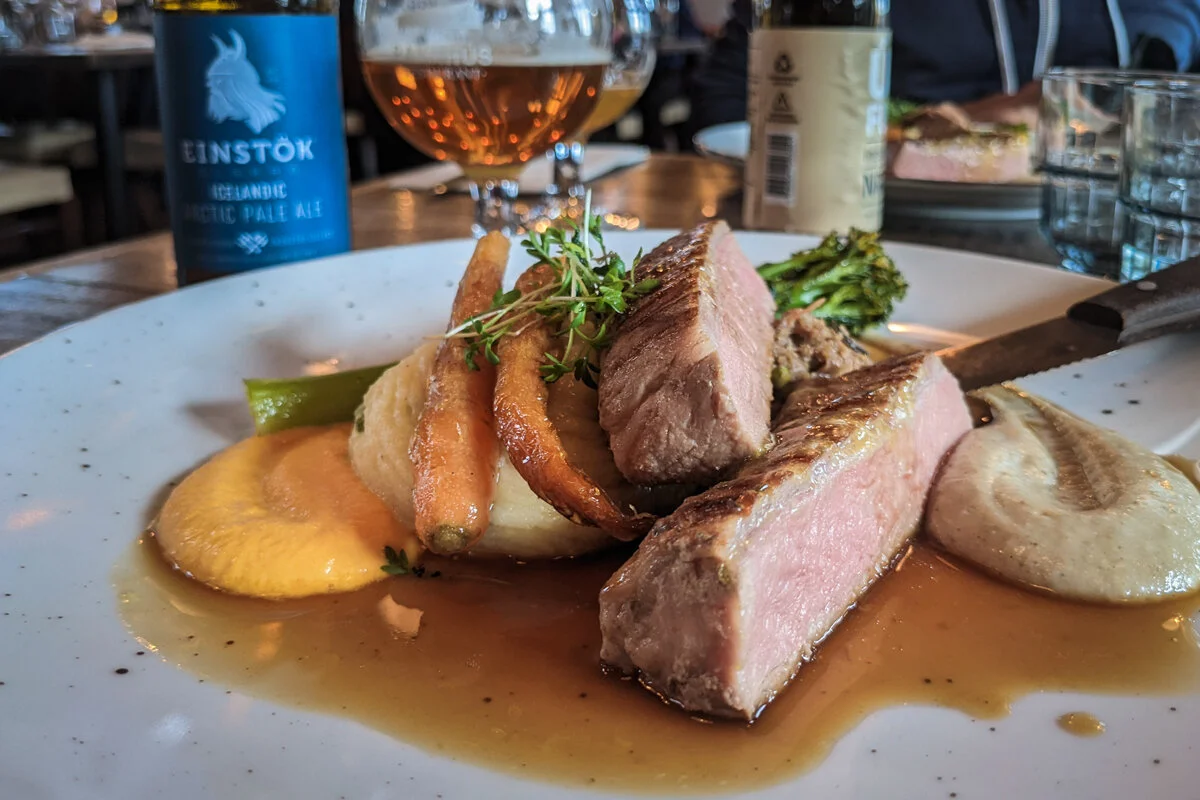 viande rôtie tranché avec sauce et accompagnements sur une assiette
