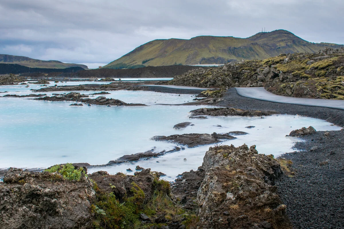 lagon géothermique aux eaux turquoise entouré de roches volcaniques