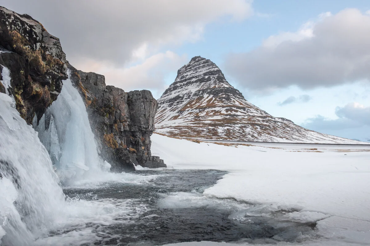 montagne de Kirkjufell enneigée avec cascade gelée au premier plan