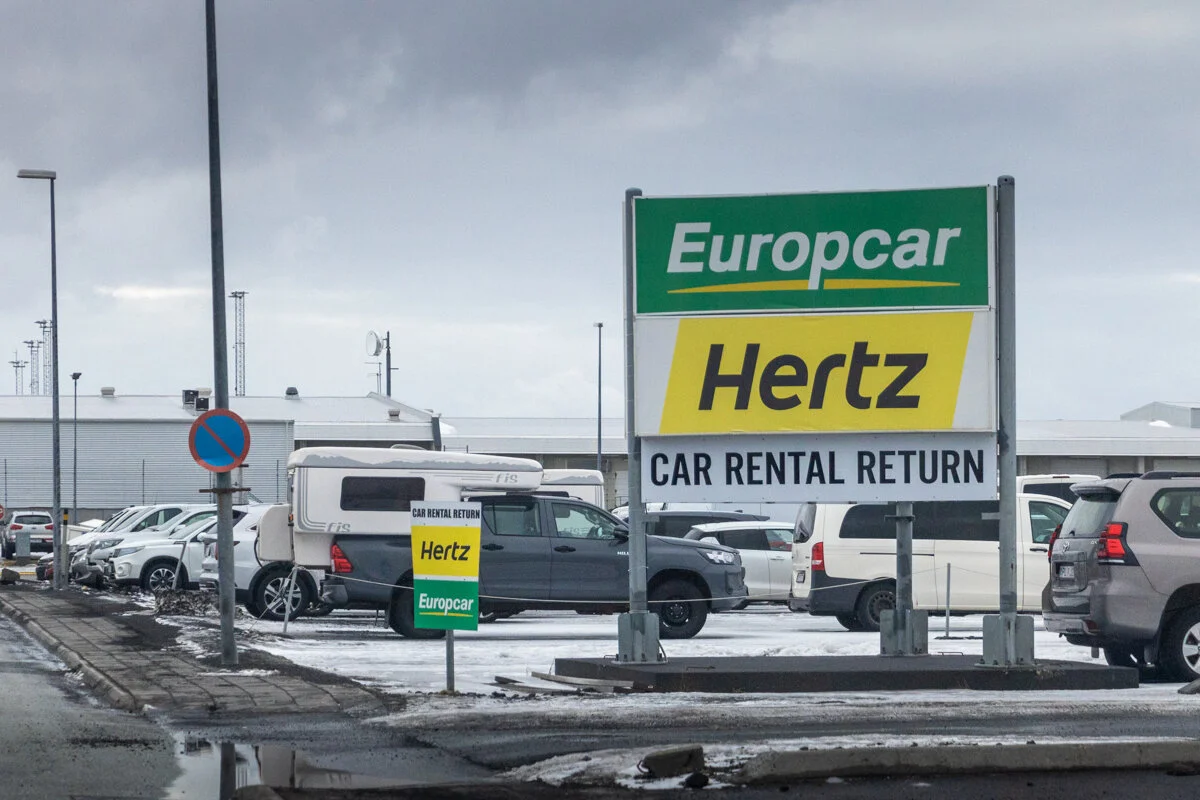 panneau de location de voitures Europcar et Hertz dans un parking