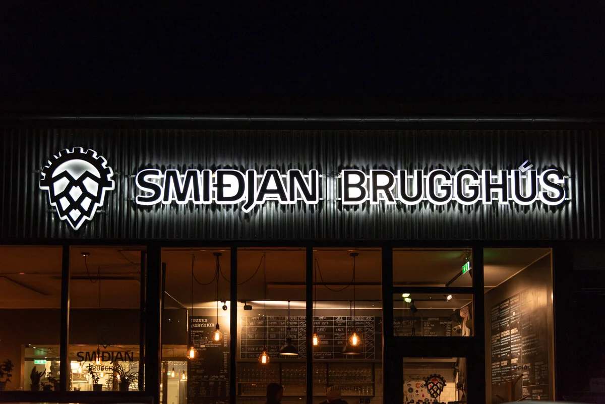 devanture du restaurant "Smidjan Brugghus" illuminée la nuit avec enseigne