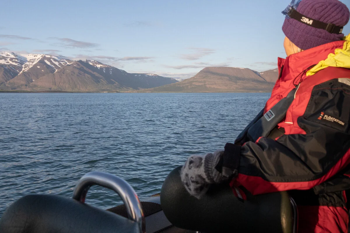 personne en gilet de sauvetage sur un bateau qui regarde la paysage