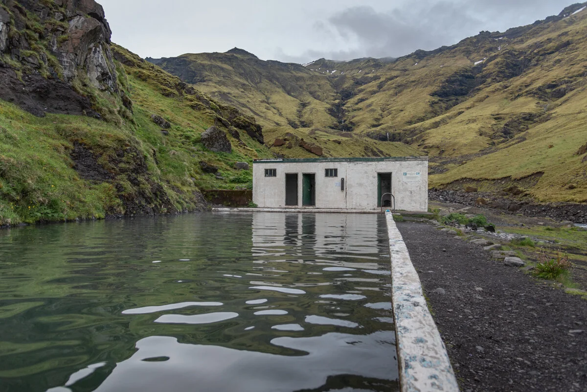 cabanon blanc au bord d'une piscine extérieure dans une vallée montagneuse