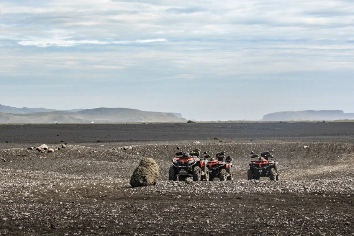 des personnes assises sur des quads dans un paysage désertique