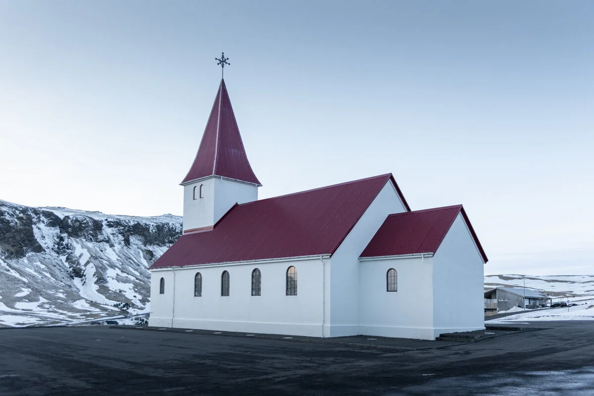 église blanche avec toit rouge dans un paysage montagneux