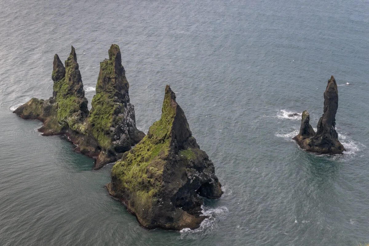 rochers émergeant de l'océan avec de la végétation, vus d'en haut