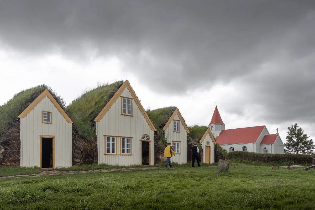 rangée de petites maisons en bois avec toits couverts d'herbe