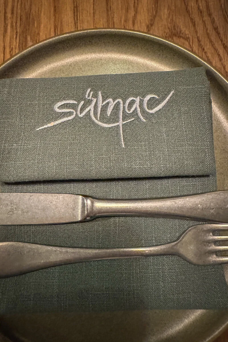 serviette de table avec "Samac" écrit dessus, couverts posés dessus