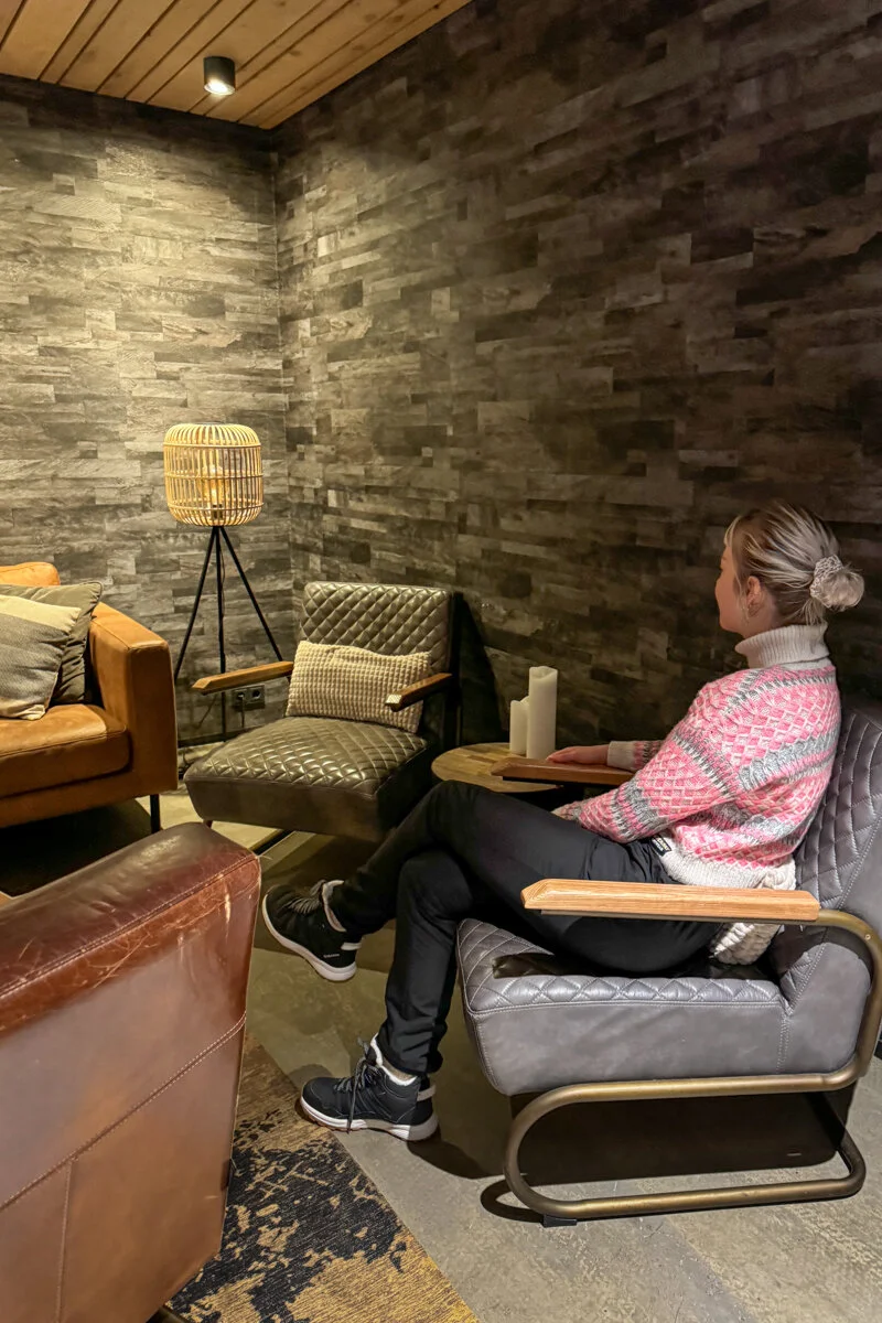 une femme assise dans un fauteuil dans un lobby d'hôtel