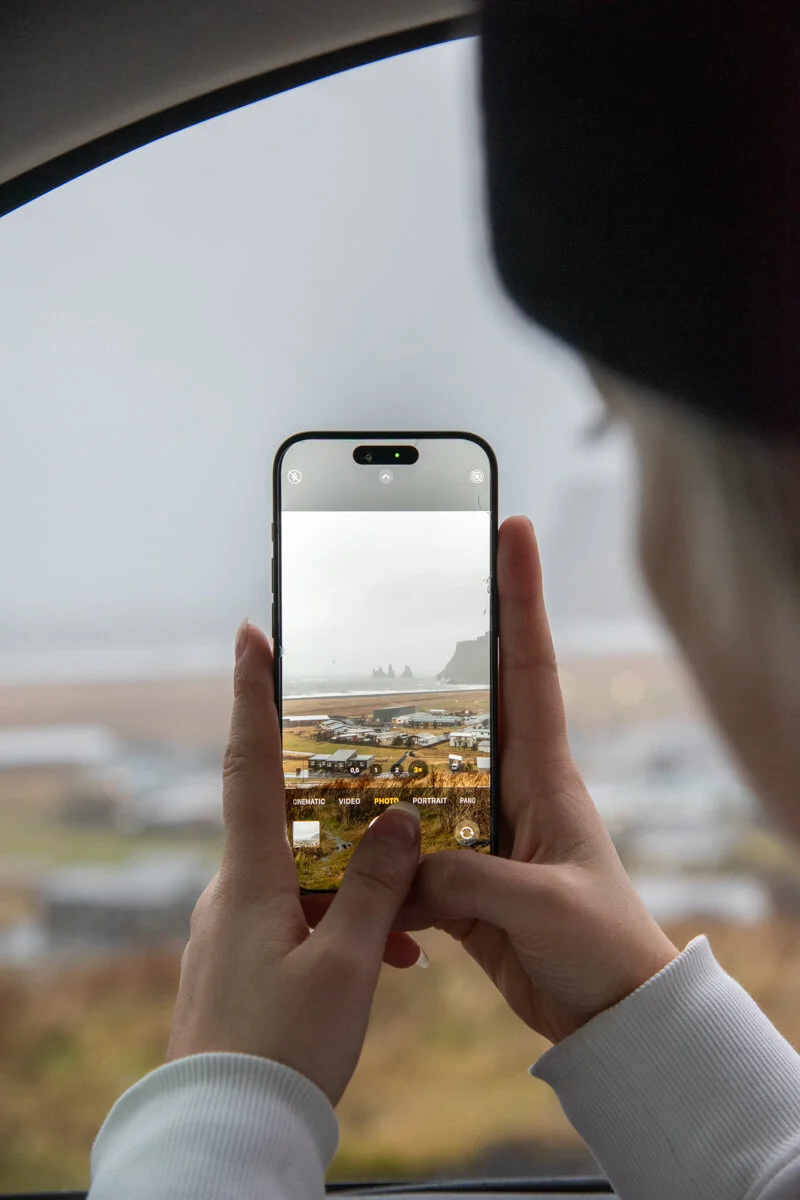 une personne photographie un paysage avec son téléphone