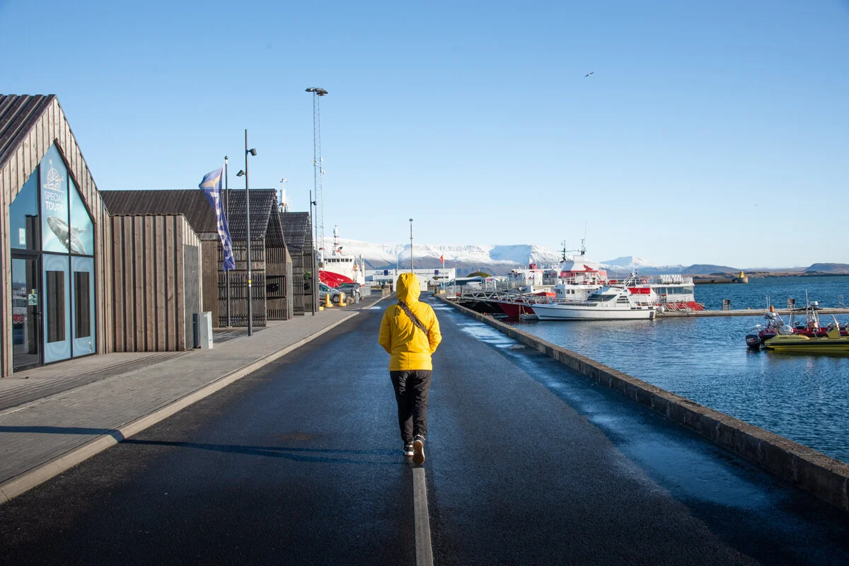 personne avec un ciré jaune qui marche sur la jetée