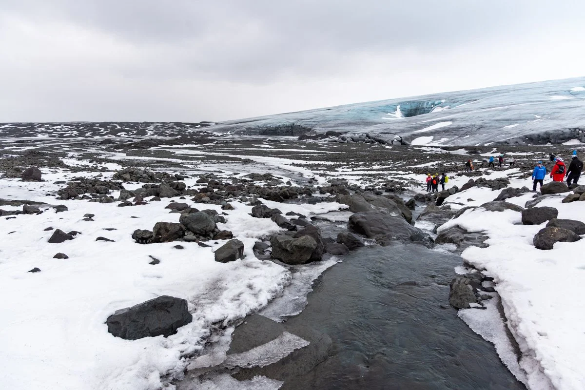 un ruisseau hivernal traversant un paysage enneigé et rocheux