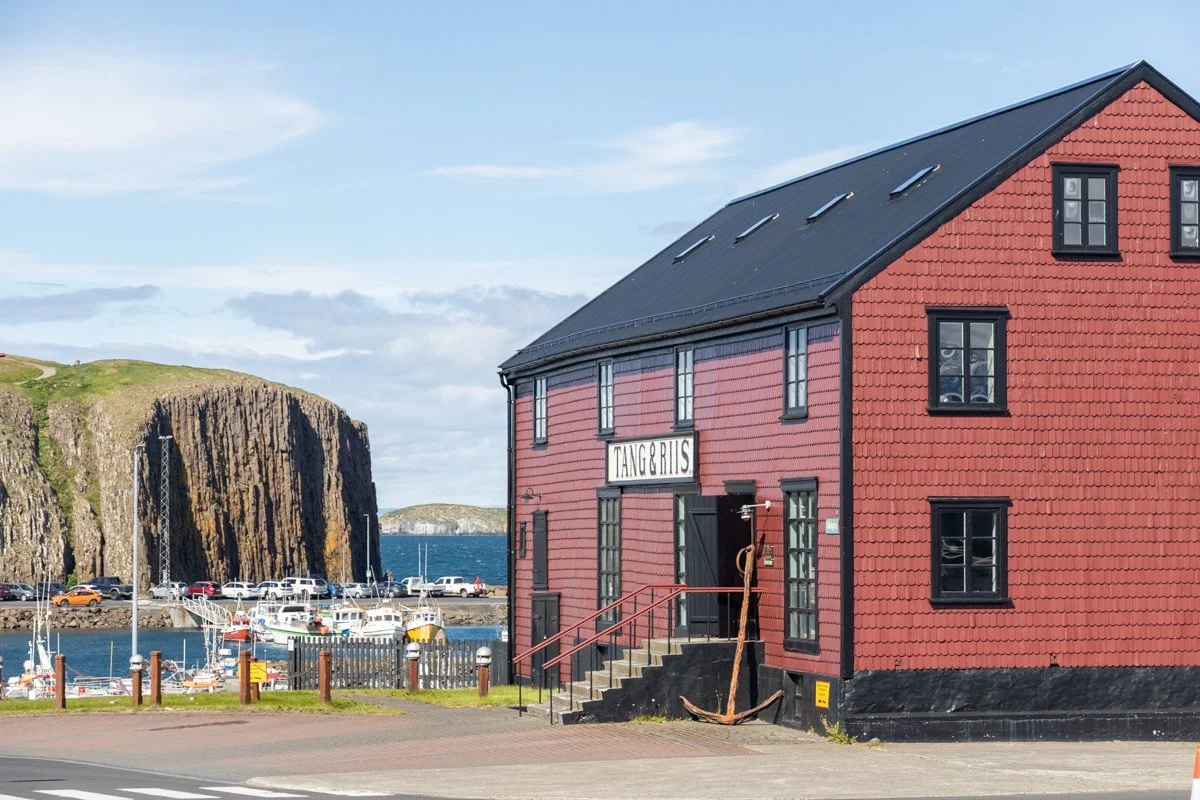 maison rouge avec façade en bois près d'une côte