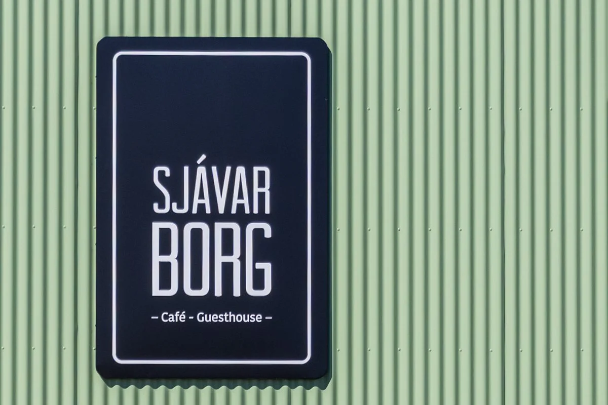 enseigne "Sjávarborg" d'un café-restaurant sur une façade verte